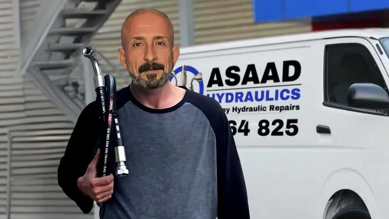 Asaad holding two hydraulic hoses in front of the Asaad Hydraulics van