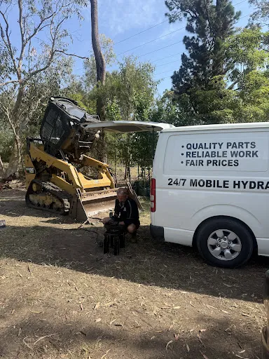 A track loader beside the Asaad van