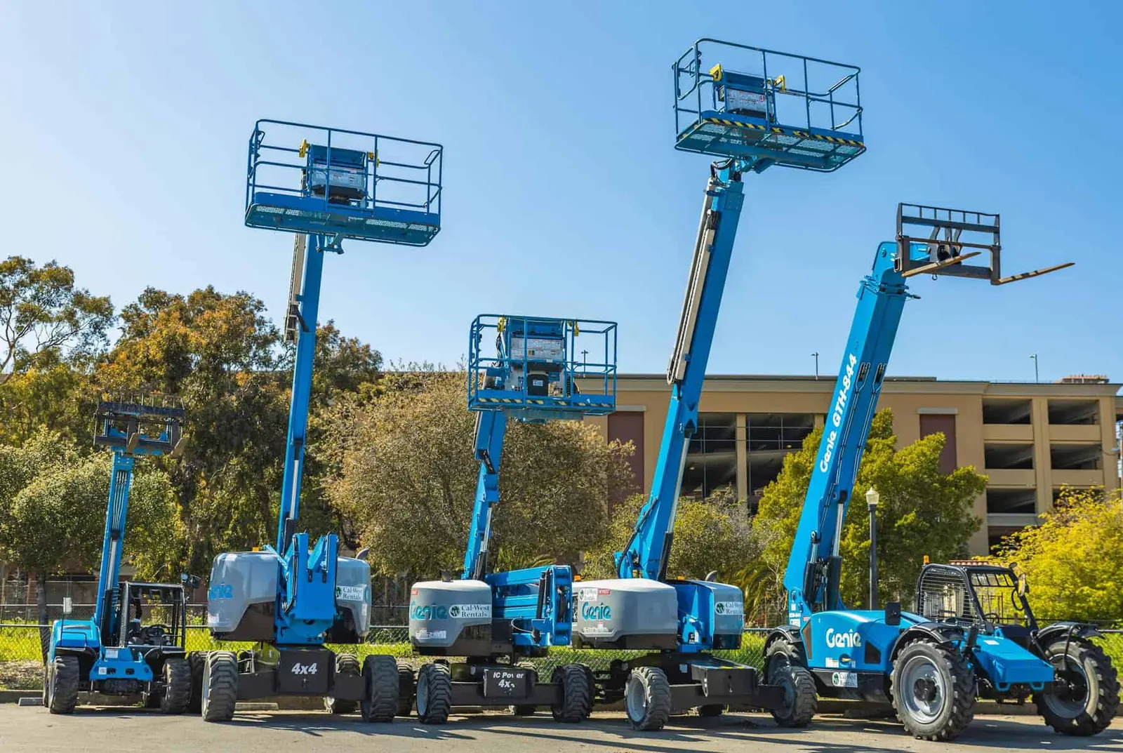 Row of blue aerial work platforms and telehandlers