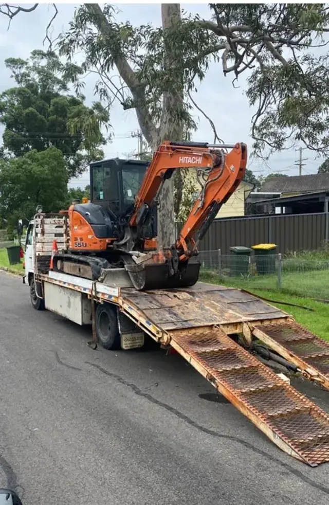 Excavator on a tilt-tray truck