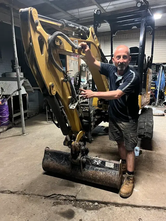 Compact excavator in a workshop bay